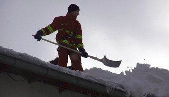 Mann auf Dach beim Schneeschippen ©DLRG Passau