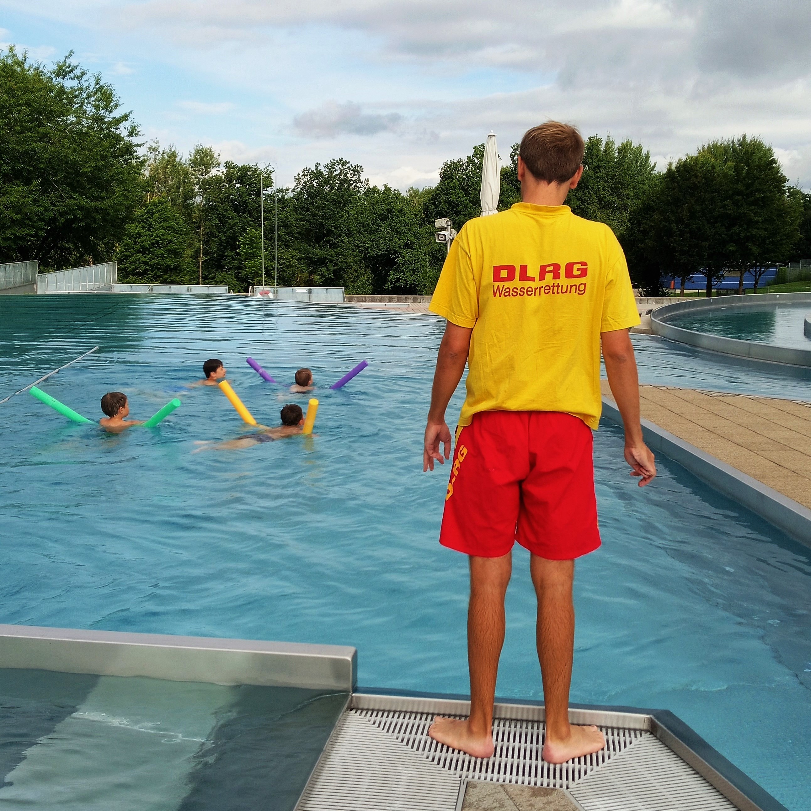 Schwimmkurs - Trainer am Beckenrand und Kinder im Wasser ©Anna Klostermann